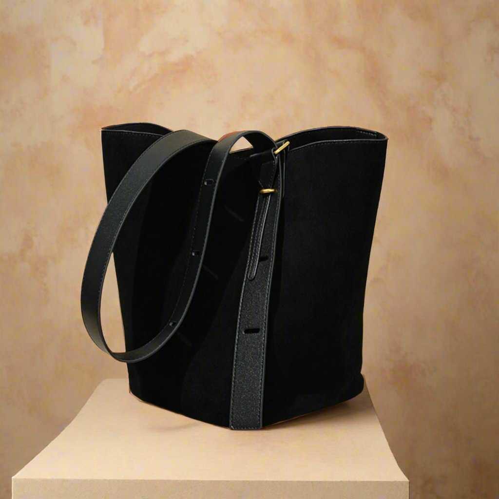 Suede Bucket Bag on display with adjustable strap and elegant black nubuck leather design.