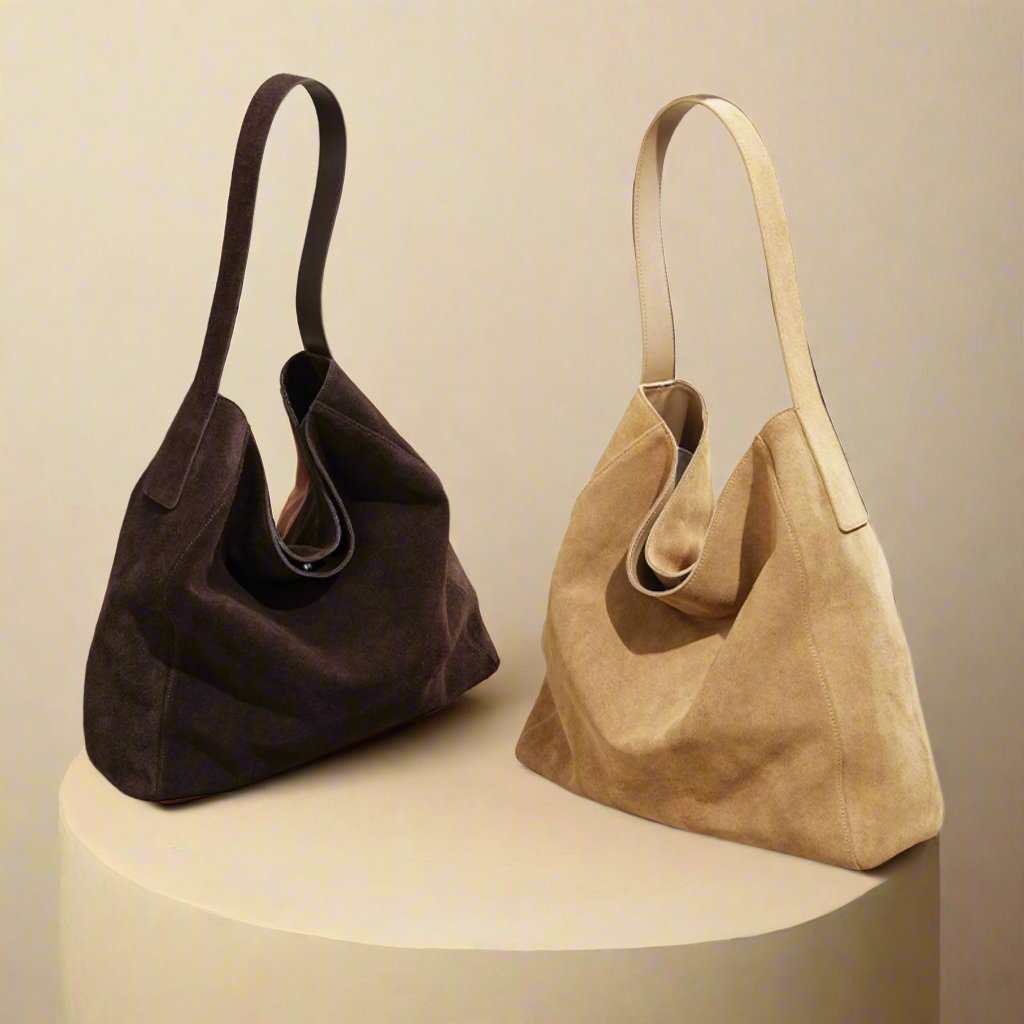 Two suede slouch bags with single-shoulder design and reinforced bottoms.