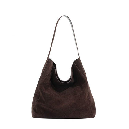 Suede slouch bag with single shoulder strap and spacious interior.