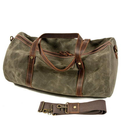 Waxed canvas duffle bag with genuine leather handles and detachable shoulder strap, ideal for travel.