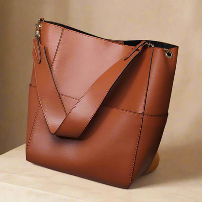 Elegant brown leather women's bucket bag with adjustable strap, ideal for stylish storage and organization.