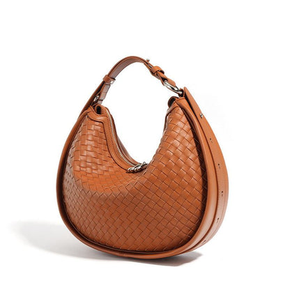 Woven leather crossbody bag in caramel color with adjustable strap and sleek design.