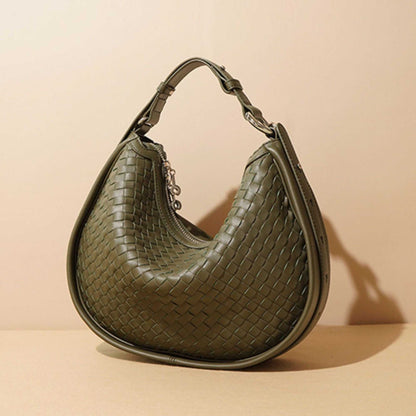 Woven leather crossbody bag in sage green with adjustable strap and stylish design.