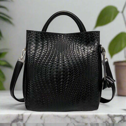 Woven Leather Handbag with elegant woven pattern on a marble surface.