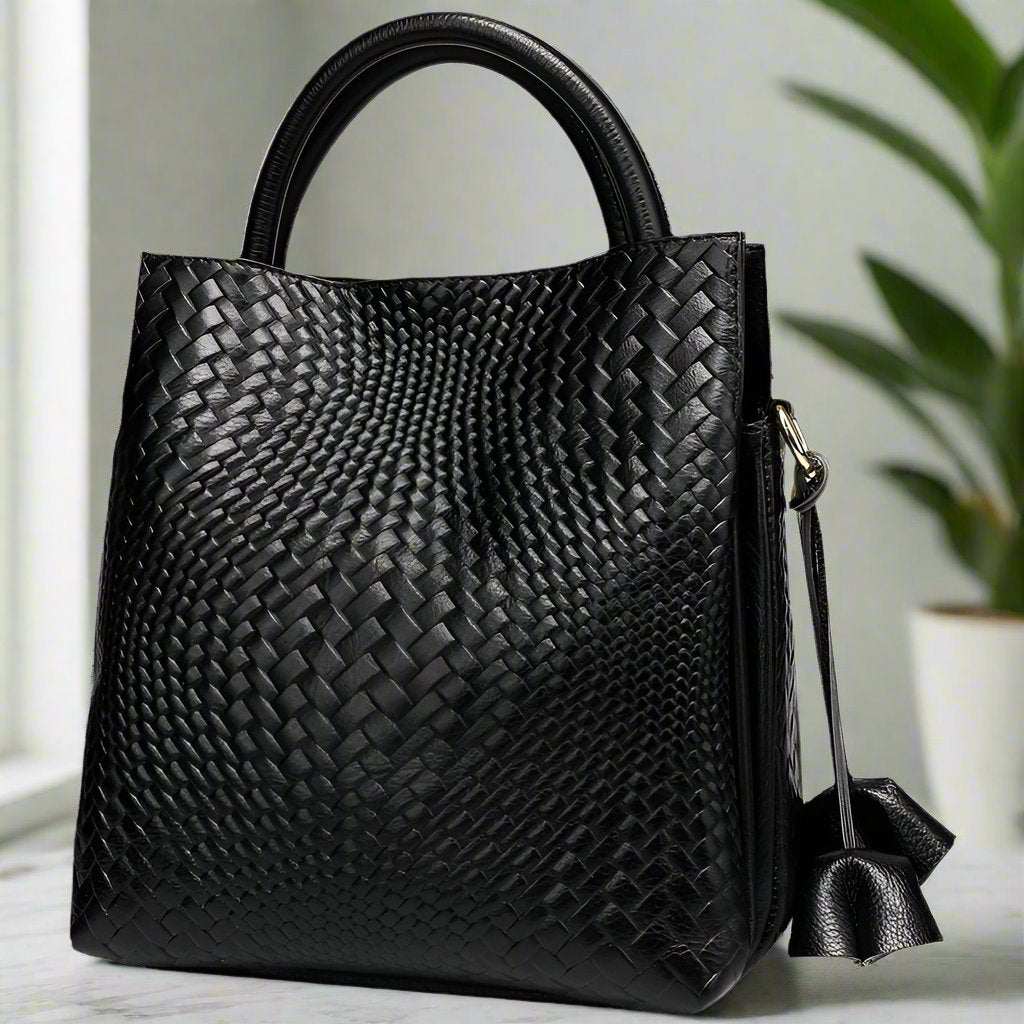 Elegant black woven leather handbag with sturdy handles and bold design.