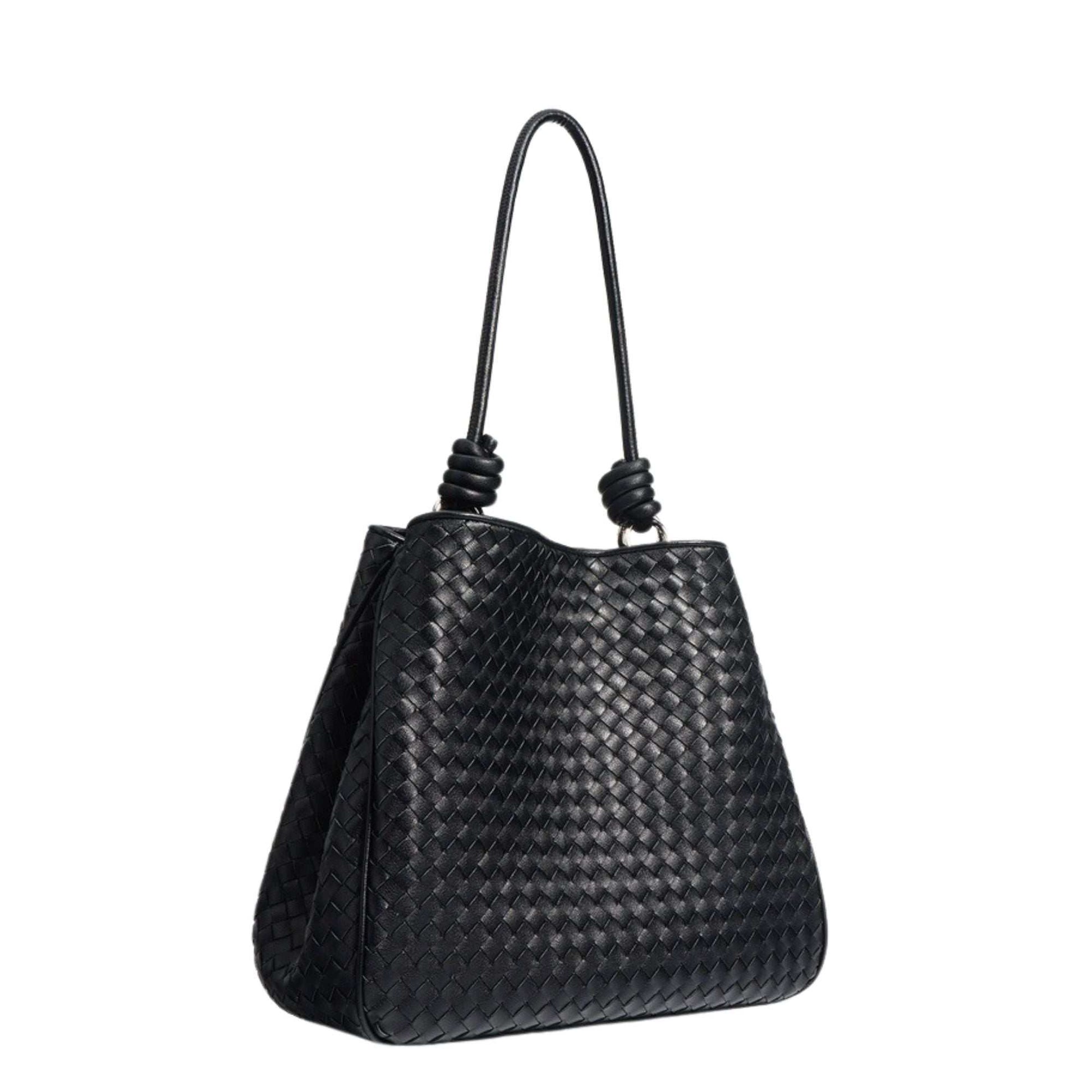 Black woven leather tote bag with braided design and leather rod handles.