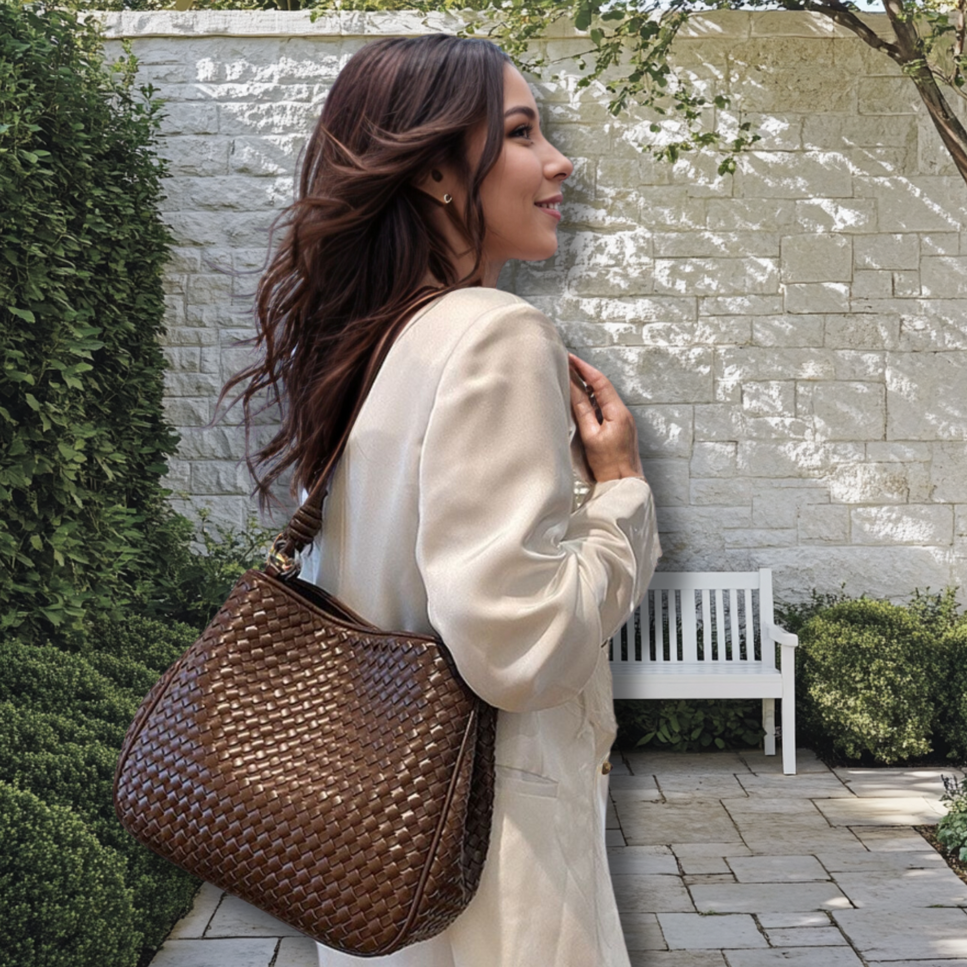 Woman carrying the Woven Leather Tote Bag in a garden setting.