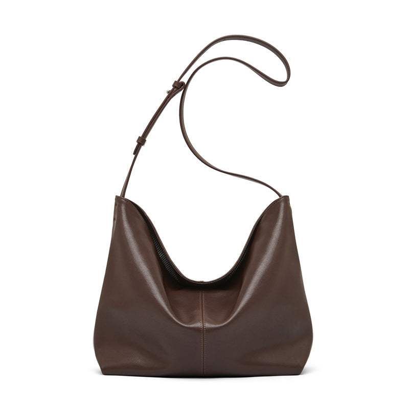 Slouchy leather purse with adjustable shoulder strap in brown.