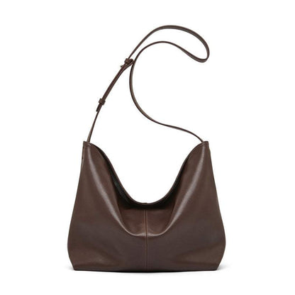 Slouchy brown leather purse with adjustable strap and spacious design.